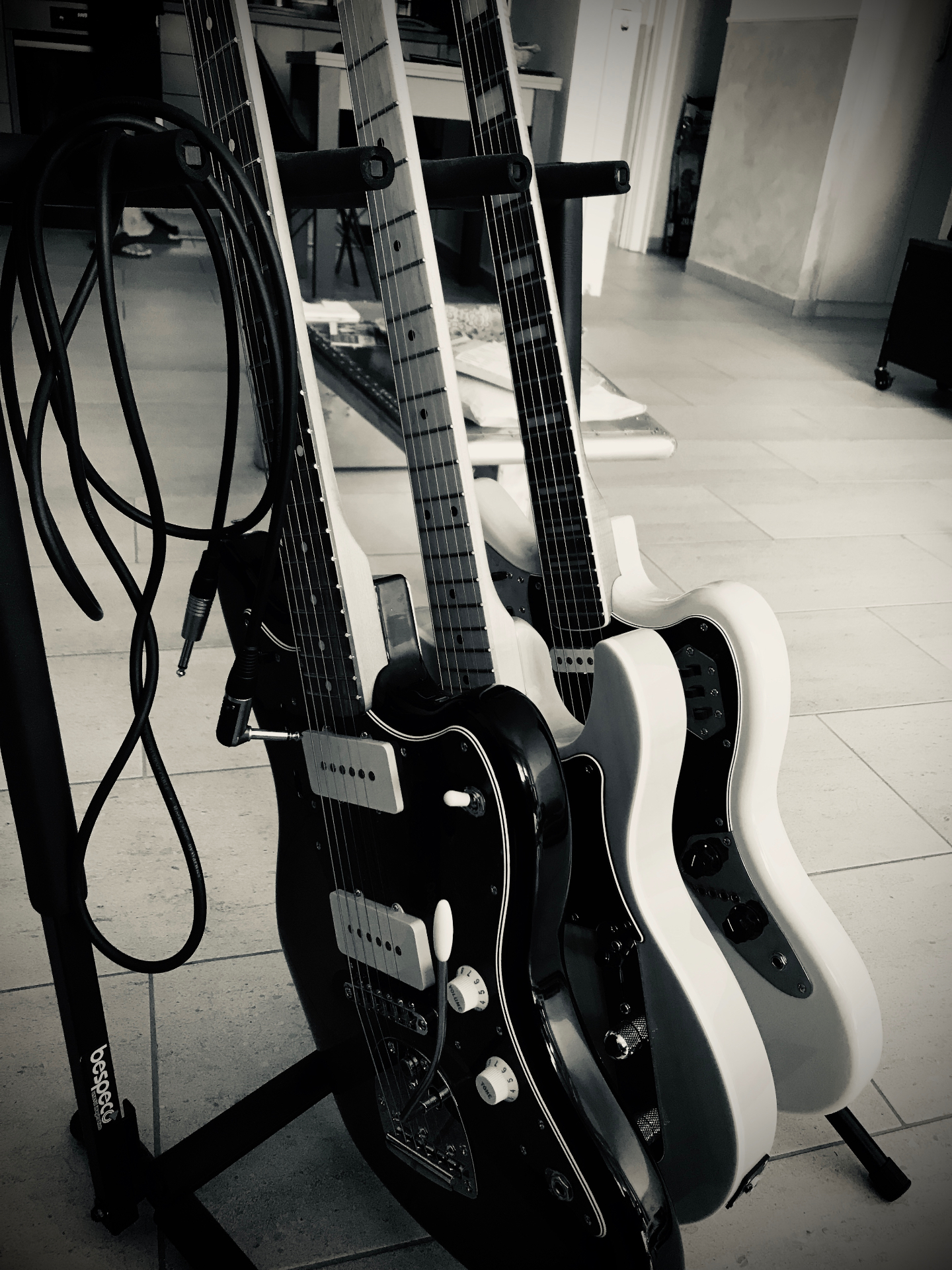 Black and white electric guitars on a stand
